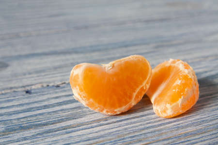 Tangerine mandarin slices on wooden backgroundの写真素材