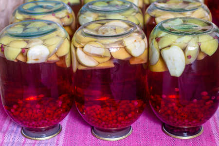 Homemade canned fruit compote for the winter. Compot from apples and red currant. Inverted jarsの写真素材