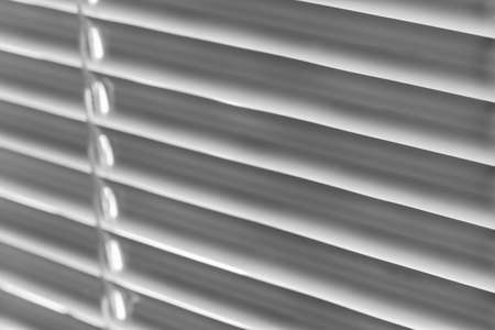 White jalousie background. Closeup, selective focus, black and white photoの写真素材
