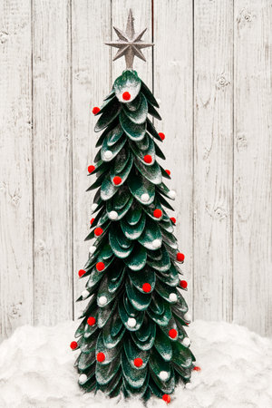 Handmade Christmas tree from plastic spoons decorated with multi-colored soft Christmas toys and...