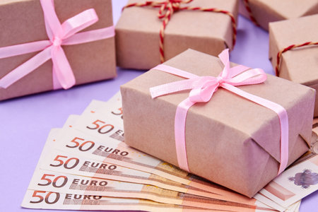 Christmas or New Year gift box on euros against a background of boxes. Money as a gift for Christmas