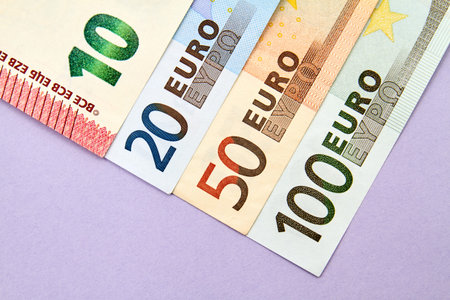 10, 20, 50, 100 Euro banknotes on purple background