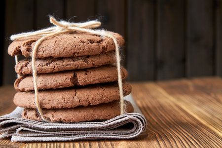 Stacked cookies on brown napkin and on wooden table