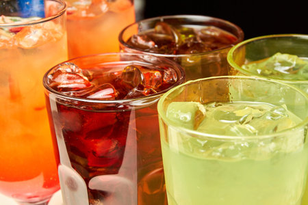 Multicolored alcoholic and non-alcoholic cocktails with ice and straws