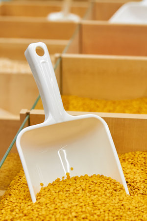 Yellow peas in a tray with a plastic grain spatula in a supermarketの写真素材