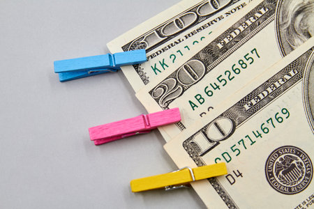 10, 20, 100 US dollar banknotes with decorative clothespins on gray backgroundの写真素材