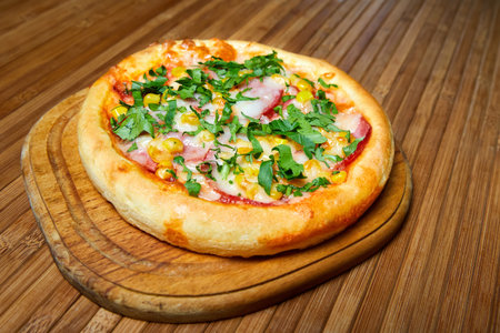 Pizza with cheese, bacon and herbs on a wooden plate. Close-up, selective focus