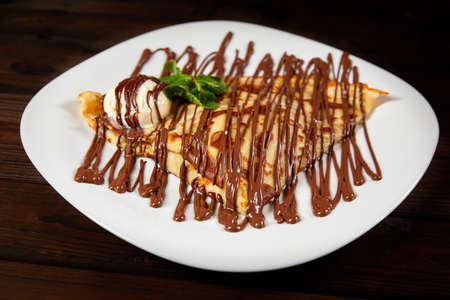 Pancake with a scoop of ice cream and chocolate. Close-up, selective focusの写真素材