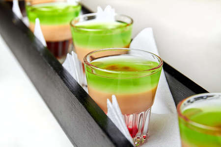 Several multicolored alcoholic drinks shots on the bar counterの写真素材