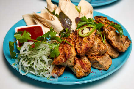 Pork shashlik or Kebab with lavash, pickled onions and red sauceの写真素材