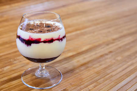 Creamy dessert with jam and chocolate in a glass. Close-up, selective focusの写真素材