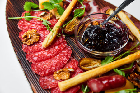 Assorted cheeses and meat delicacies on wooden board. Close-up, selective focusの写真素材