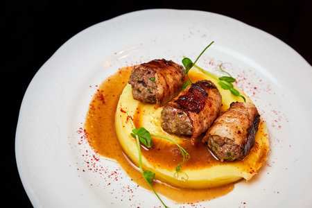 Veal kebab in bacon with mashed potatoes. Close-up, selective focus