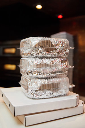 Stack of white closed cardboard pizza boxes and lunch boxes prepared for delivery. Close-up, selective focusの写真素材