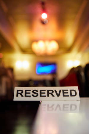 Plastic plaque with the inscription Reserved on the restaurant tableの写真素材