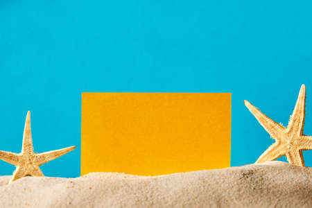 Summer background on sand decorated with starfish and yellow copy spaceの写真素材