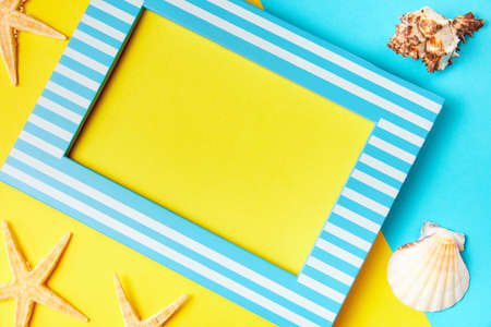 Picture frame with copy space and starfish on a yellow-blue backgroundの写真素材