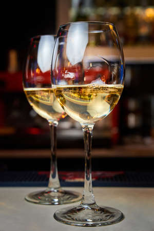 Two glasses of white wine on the bar. Close-up, selective focusの写真素材