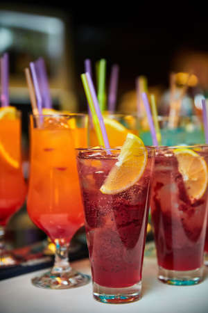 Multicolored alcoholic and non-alcoholic cocktails with ice and strawsの写真素材