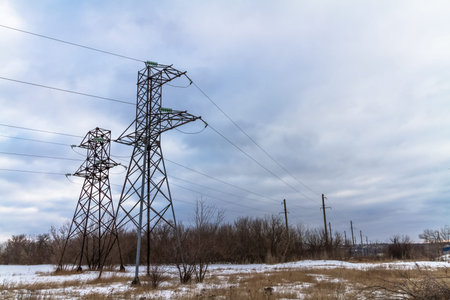 High voltage power lines against the background of a cloudy sky.
