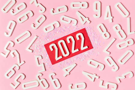 Pink background of numbers with lettering in the center 2022, decorated with Christmas sparklesの写真素材