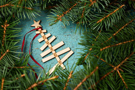 New Year composition from Wooden Christmas tree on a blue paper background surrounded by fir branchesの写真素材