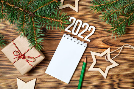 Blank notepad with gift box, wooden stars and fir branches on wooden backgroundの写真素材