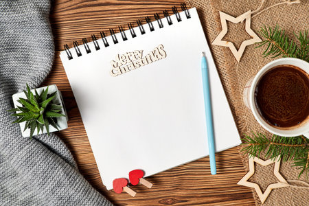 Christmas composition of open blank notepad, coffee cup, scarf, Cactus and fir branches on wooden...