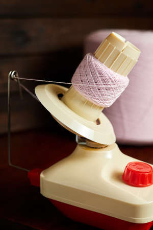 Mechanical yarn winder or reel while rewinding thread. Close-up, selective focusの写真素材