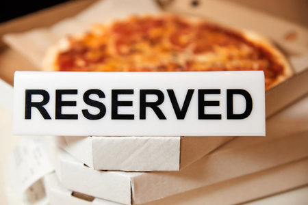 Plastic plaque with the inscription Reserved on the open box with pizza