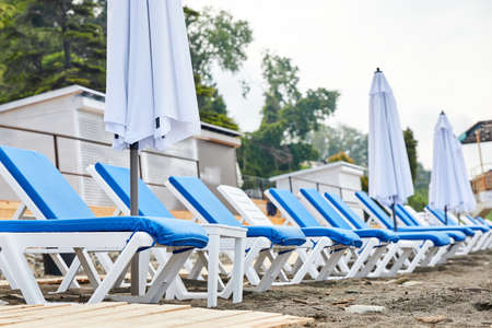 Sun loungers with blue mattresses on the beachの写真素材