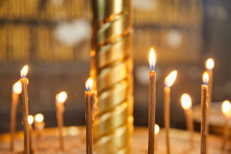 Group of burning church candles at blurred backgroundの写真素材