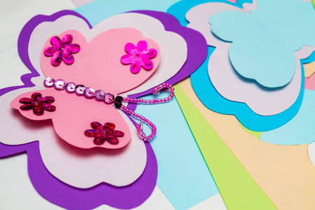 Application made with hot melt glue gun. Butterfly made of colored paper, multi-colored sequins,...