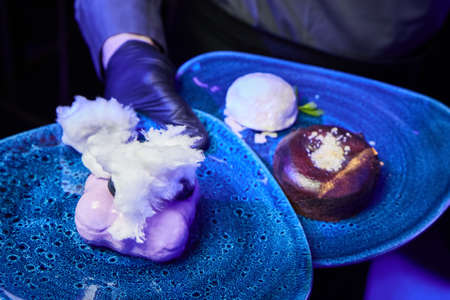 Waiter holding plates with dessertsの写真素材