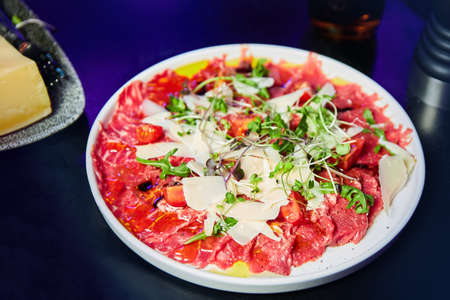 Carpaccio with arugula and parmesan in the restaurantの写真素材