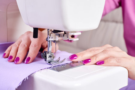 Woman sewing a dress on a sewing machine. Close up, selective focusの写真素材