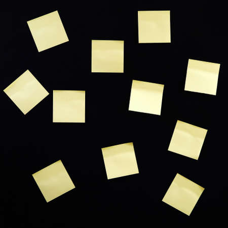 Blank yellow paper sticker notes on dark backgroundの写真素材