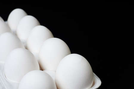 Tray with white chicken eggs on a dark backgroundの写真素材