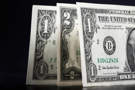One and two dollar bills on a dark surface