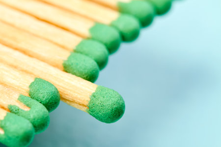 Close-up of a row of matches with green heads on a blue backgroundの写真素材