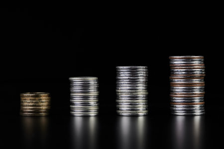 Stacks of metallic coins on a dark backgroundの写真素材