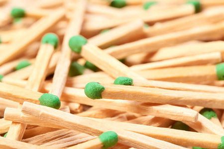 Close-up of a green match head against the background of randomly scattered matchesの写真素材