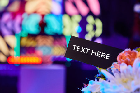 A blank black card with space for text against the backdrop of multi-colored lights of a nightclub