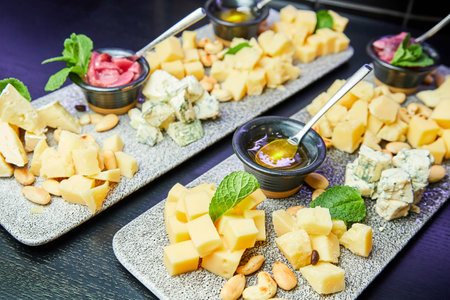 Cheese plates with nuts and honey on a wooden board. Close up, selective focusの写真素材