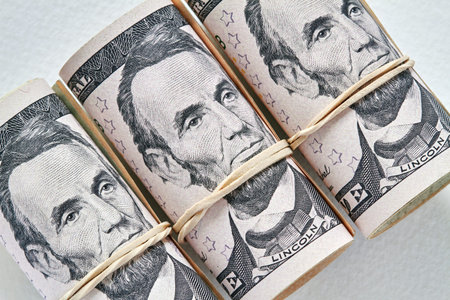 American twenty dollar banknotes rolled up as a tubule. Light background, closeup, selective focus