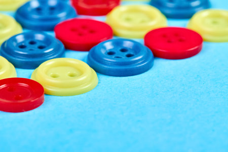 Multicolored buttons for clothes on a blue background. Close up, selective focusの写真素材