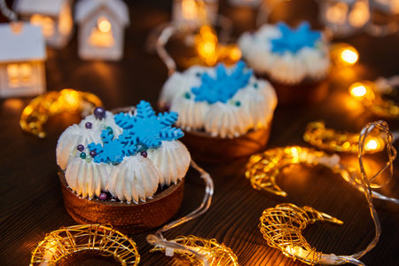 Christmas cakes with chocolate sand tartlet, cherry compote and vanilla ganache on a background of glowing garlandsの写真素材