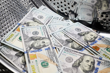 Close-up of washing dollars in machine, money laundering, financial fraud conceptの写真素材