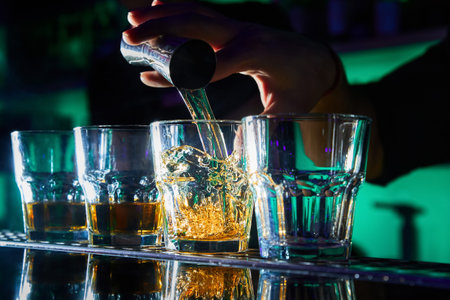 The bartender prepares red cocktails on the bar counter
