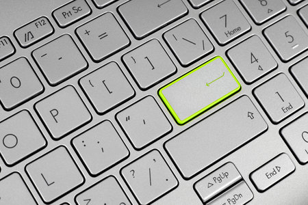 Laptop keyboard with enter key highlighted in light greenの写真素材